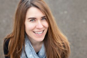 Photo of the author with light brunette hair, smiling at the camera